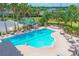 Aerial view of a sparkling community pool with lounge chairs, tables, and lush landscaping at 7930 111Th Ter E, Parrish, FL 34219