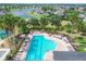 Aerial view of a community pool with lounge chairs, tables, and lush landscaping, offering a relaxing atmosphere at 7930 111Th Ter E, Parrish, FL 34219