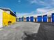 Storage units featuring vibrant blue doors and a secure yellow gate, set in a well-maintained and modern complex at 8100 Ciboney Ct # 10, Sarasota, FL 34240