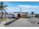 Striking exterior view with a modern design and a red door entry, complemented by a palm tree and spacious parking at 8100 Ciboney Ct # 10, Sarasota, FL 34240