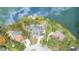 A bird's-eye view of a neighborhood situated along a serene lake, adorned with mature trees and green lawns at 9007 63Rd Avenue E Dr, Bradenton, FL 34202