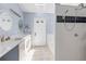 Bright bathroom featuring a double sink vanity, tiled floor, skylight, walk-in shower, and soaking tub at 9007 63Rd Avenue E Dr, Bradenton, FL 34202