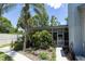 Back of home, featuring a cozy sunroom, lush landscaping, and a well-maintained pathway at 9007 63Rd Avenue E Dr, Bradenton, FL 34202