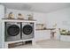 Bright laundry room with white cabinets, countertop, and modern appliances at 9007 63Rd Avenue E Dr, Bradenton, FL 34202