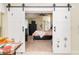 Bedroom featuring sliding barn doors and a patterned bedspread at 9007 63Rd Avenue E Dr, Bradenton, FL 34202