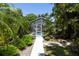 Backyard pool featuring a screen enclosure, landscaping, and a walkway surrounded by lush tropical foliage at 9007 63Rd Avenue E Dr, Bradenton, FL 34202