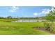 Landscaped backyard with lush green grass and a tranquil pond at 10254 Morning Mist Ln, Sarasota, FL 34241