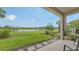 Covered patio overlooking landscaped backyard and serene water feature at 10254 Morning Mist Ln, Sarasota, FL 34241