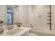 Well-lit bathroom featuring white vanity, sink, and shower with a decorative shower niche at 10254 Morning Mist Ln, Sarasota, FL 34241