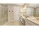 Bright bathroom featuring double sinks, quartz countertops, and a modern glass shower at 10254 Morning Mist Ln, Sarasota, FL 34241