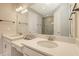 Bright bathroom featuring double sinks, quartz countertops, and a modern glass shower at 10254 Morning Mist Ln, Sarasota, FL 34241