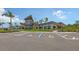 Community clubhouse featuring designated accessible parking spaces and lush landscaping on a bright, sunny day at 10254 Morning Mist Ln, Sarasota, FL 34241