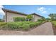 Beautiful landscaping surrounding home exterior with brick walkway at 10254 Morning Mist Ln, Sarasota, FL 34241