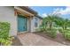 Front entrance with bright teal door, tile walkway, and tropical landscaping at 10254 Morning Mist Ln, Sarasota, FL 34241