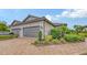 Home exterior featuring a two-car garage, brick driveway, beautiful landscaping, and tile roof at 10254 Morning Mist Ln, Sarasota, FL 34241