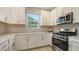 Bright kitchen featuring white cabinets, stainless steel appliances, and modern backsplash at 10254 Morning Mist Ln, Sarasota, FL 34241
