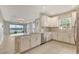 Beautiful kitchen boasts white cabinets, stainless appliances, and a stylish backsplash overlooking a lake at 10254 Morning Mist Ln, Sarasota, FL 34241