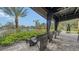 Covered outdoor seating area offering a tranquil setting with resort-style pool views and beautiful landscaping at 10254 Morning Mist Ln, Sarasota, FL 34241