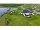 Aerial view of a charming picnic area with tables, a lakeside dock, and a quaint building surrounded by landscaped grounds at 10254 Morning Mist Ln, Sarasota, FL 34241