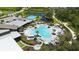 A stunning aerial view of the resort-style community pool featuring a unique design, palm trees, and lounge chairs at 10254 Morning Mist Ln, Sarasota, FL 34241