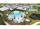 An aerial view of the clover-shaped community pool, surrounded by lush landscaping, lounge chairs, and cabanas at 10254 Morning Mist Ln, Sarasota, FL 34241