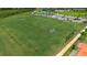 Aerial view of a green soccer field with white nets and a tennis court, bordered by trees and a running track at 10254 Morning Mist Ln, Sarasota, FL 34241