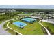 Aerial view featuring tennis and basketball courts in a community with a nearby pond, landscaping, and walking paths at 10254 Morning Mist Ln, Sarasota, FL 34241