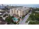 Stunning aerial view of condo building with a pool and lush landscaping near the water at 1064 N Tamiami Trl # 1125, Sarasota, FL 34236