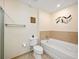 Well-lit bathroom features a soaking tub with tiled surround, toilet, and shower with a neutral color scheme at 1064 N Tamiami Trl # 1125, Sarasota, FL 34236