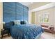 Stylish bedroom with a blue padded wall, comfortable bed, and a cozy seating area by the window at 1064 N Tamiami Trl # 1125, Sarasota, FL 34236