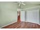 Bright bedroom features wood floors, a ceiling fan, and spacious closet at 1112 Golfview Woods Dr # 1112, Sun City Center, FL 33573