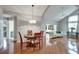 Dining area open to the living room featuring hardwood floors and a stylish hanging chandelier at 1112 Golfview Woods Dr # 1112, Sun City Center, FL 33573