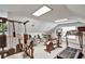 Bright home gym featuring various exercise machines, including a treadmill, elliptical, and weightlifting station under skylights at 1112 Golfview Woods Dr # 1112, Sun City Center, FL 33573