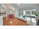 Open-concept living room with hardwood floors, lots of light, and a view of the screened porch at 1112 Golfview Woods Dr # 1112, Sun City Center, FL 33573