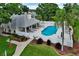 Community pool with a white fence, surrounded by landscaping and trees, with lounge chairs for relaxing by the poolside at 1112 Golfview Woods Dr # 1112, Sun City Center, FL 33573