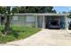 Charming single-story home with a covered parking area, a well-maintained lawn, and mature trees at 11707 104Th St, Largo, FL 33773