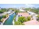 Lovely canal-front home with a red roof surrounded by lush greenery and serene water views at 1240 Solitude Ln, Sarasota, FL 34242