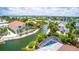 Stunning aerial view of a waterfront home with a pool and boat dock surrounded by lush landscaping at 1240 Solitude Ln, Sarasota, FL 34242
