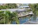 Exterior view of backyard with deck, dock, boats, screened-in porch and beautiful tropical foliage at 1240 Solitude Ln, Sarasota, FL 34242