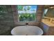 Modern bathroom with a freestanding tub, garden view window, and stylish tile accents at 1240 Solitude Ln, Sarasota, FL 34242