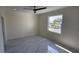 Bright bedroom with marble-patterned tile, a ceiling fan, and a window overlooking the outdoors at 1240 Solitude Ln, Sarasota, FL 34242