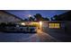 Charming home exterior featuring a picket fence, stone accents, and a well-lit entrance at twilight at 1240 Solitude Ln, Sarasota, FL 34242