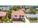 Inviting two-story home with a red tile roof, lush landscaping, and a modern garage door at 1240 Solitude Ln, Sarasota, FL 34242