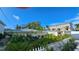 Exterior view of a home featuring tropical landscaping and a white picket fence at 1240 Solitude Ln, Sarasota, FL 34242