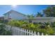 View of the home and landscaping with a partial view of the white picket fence in the yard at 1240 Solitude Ln, Sarasota, FL 34242