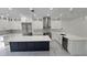 A spacious kitchen features white cabinetry, stainless steel appliances, and a large center island with a marble countertop at 1240 Solitude Ln, Sarasota, FL 34242