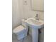 A clean and simple powder room featuring a modern pedestal sink and toilet at 1240 Solitude Ln, Sarasota, FL 34242