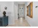 Bright hallway with tile flooring, decorative mirror, and a stylish front door view at 13422 Saw Palm Creek Trl, Lakewood Ranch, FL 34211