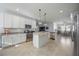 Modern kitchen with white cabinetry, granite countertops, stainless steel appliances, and a central island at 13422 Saw Palm Creek Trl, Lakewood Ranch, FL 34211
