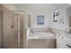 Bright bathroom featuring walk in shower, garden tub, and neutral tones at 13422 Saw Palm Creek Trl, Lakewood Ranch, FL 34211